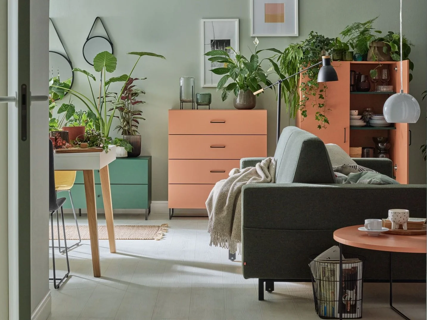 Zielono-brzoskwiniowy salon pełen roślin 
